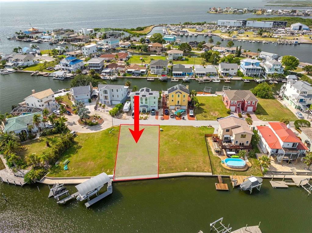 An aerial view shows a vacant waterfront lot outlined in red next to residential homes — LOT 7 LOUISE COURT, HUDSON, FL