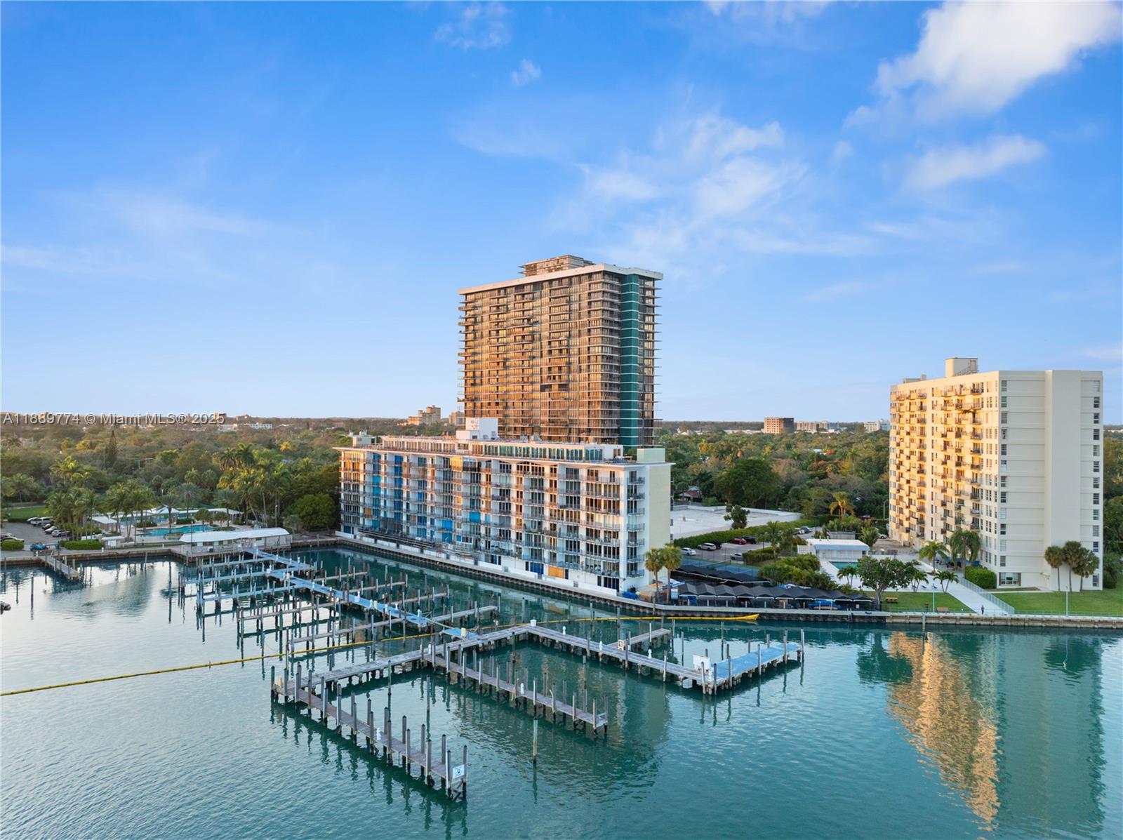 An aerial view shows a tall apartment building and a marina with wooden docks — 770 NE 69th St # 2H, Miami FL 33138, MIAMI, FL