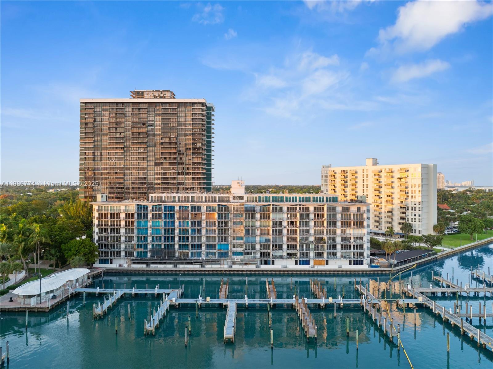 An aerial view shows a waterfront apartment building with a marina and boat docks — 770 NE 69th St # 2H, Miami FL 33138, MIAMI, FL