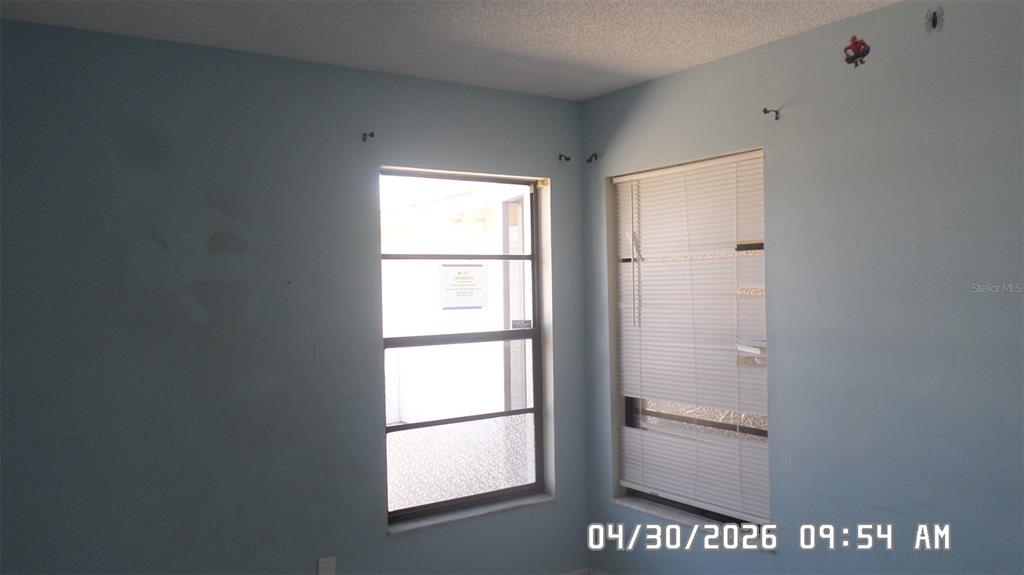 A corner of a room with light blue walls and two windows with blinds — 2665 MILL RUN BOULEVARD, KISSIMMEE, FL
