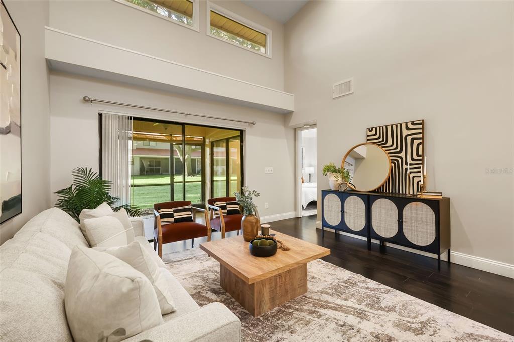 A living room features a light-colored sofa, wood coffee table, and a dark sideboard — 8209 SANDPOINT BOULEVARD, ORLANDO, FL