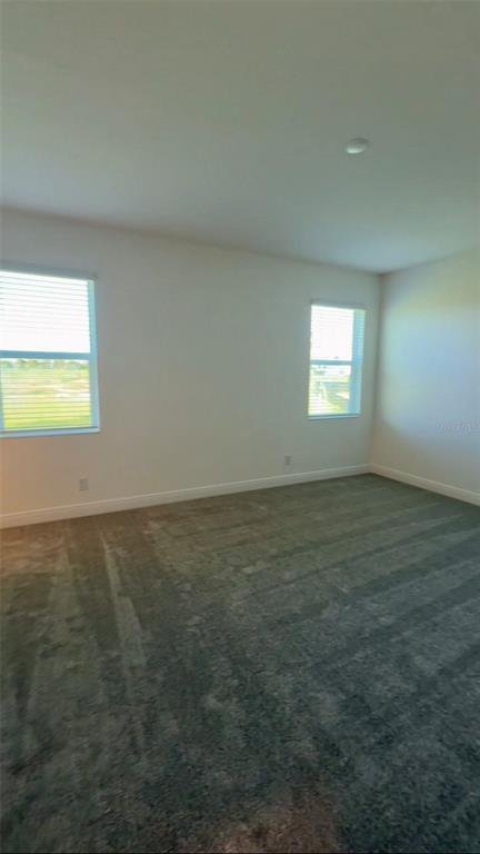 An empty bedroom features gray carpeting, white walls, and two windows with blinds — 14729 ERICE AVENUE, CLERMONT, FL