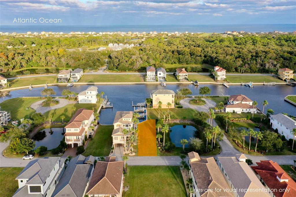 An aerial view shows a vacant waterfront lot highlighted in orange among residential homes — 297 YACHT HARBOR DRIVE, PALM COAST, FL