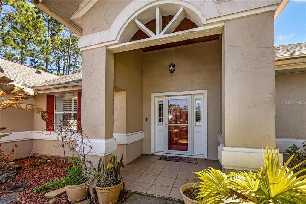 The exterior entrance features a tiled porch, a white front door, and a decorative arch — 86 FELLOWSHIP DRIVE, PALM COAST, FL