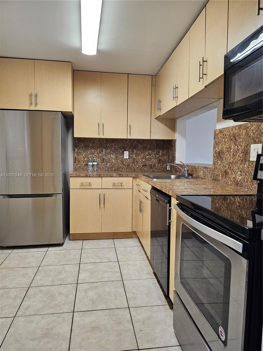 A kitchen features light wood cabinets, stainless steel appliances, and brown speckled countertops — 8005 SW 107th Ave # 305, Miami FL 33173, MIAMI, FL