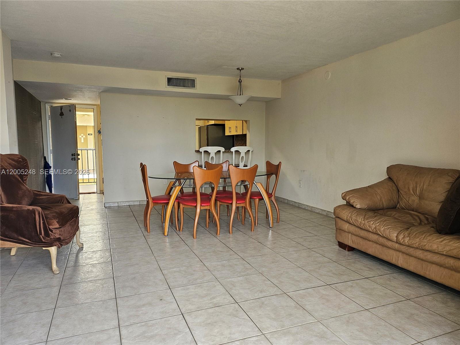 A living and dining area features tiled floors, a glass-top table, and neutral walls — 8005 SW 107th Ave # 305, Miami FL 33173, MIAMI, FL