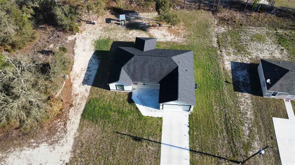 An aerial view shows a single-story house with a dark roof and a concrete driveway — 14110 SW 64TH TERRACE ROAD, OCALA, FL