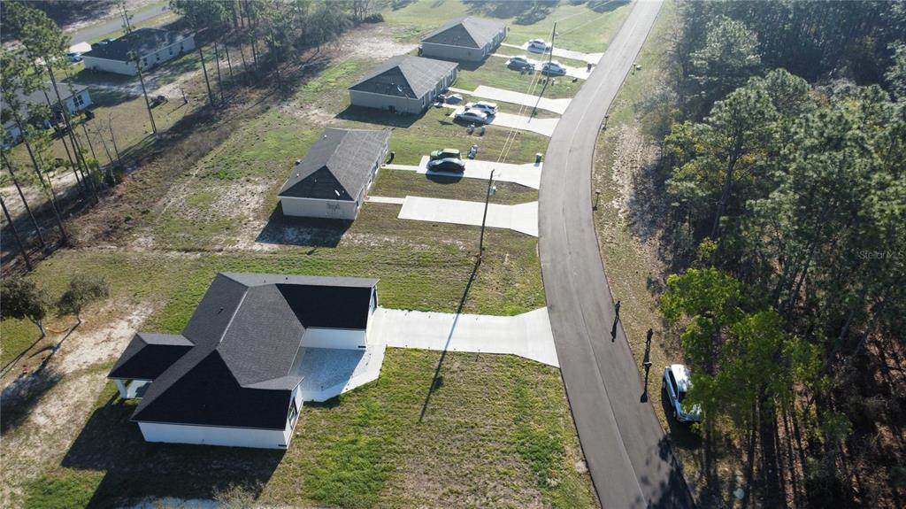 An aerial view shows several single-family homes with driveways along a paved residential road — 14110 SW 64TH TERRACE ROAD, OCALA, FL