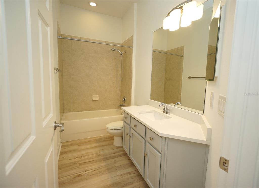 A bathroom features a vanity with a white countertop, a toilet, and a tub-shower combo — 20638 AMANDA OAK COURT, LAND O LAKES, FL