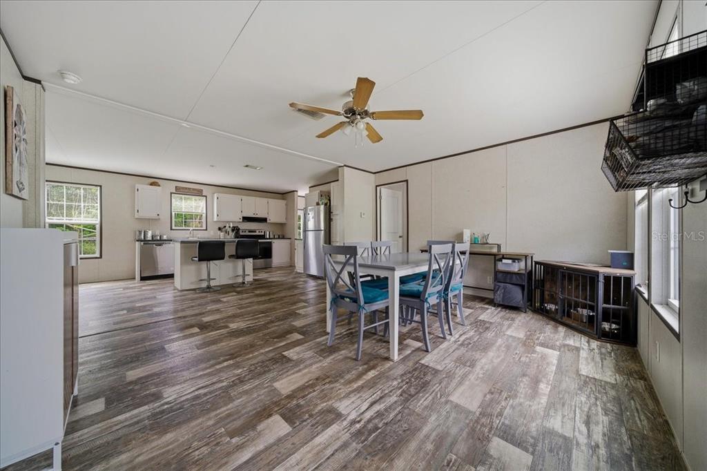 An open-concept kitchen and dining area features wood-look flooring and a ceiling fan — 444 KORBUS ROAD, BROOKSVILLE, FL