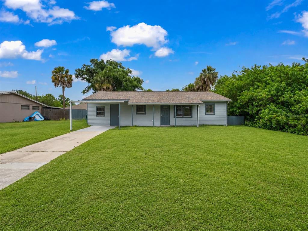 A single-story house with light gray siding, a shingled roof, and a concrete driveway — 20310 LORENZO AVENUE, PORT CHARLOTTE, FL