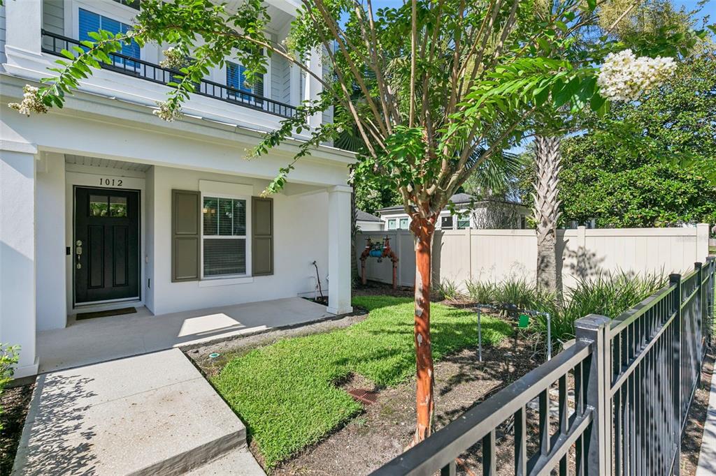 A white house exterior features a front porch, a black door, and a small lawn — 1012 E MARKS STREET, ORLANDO, FL