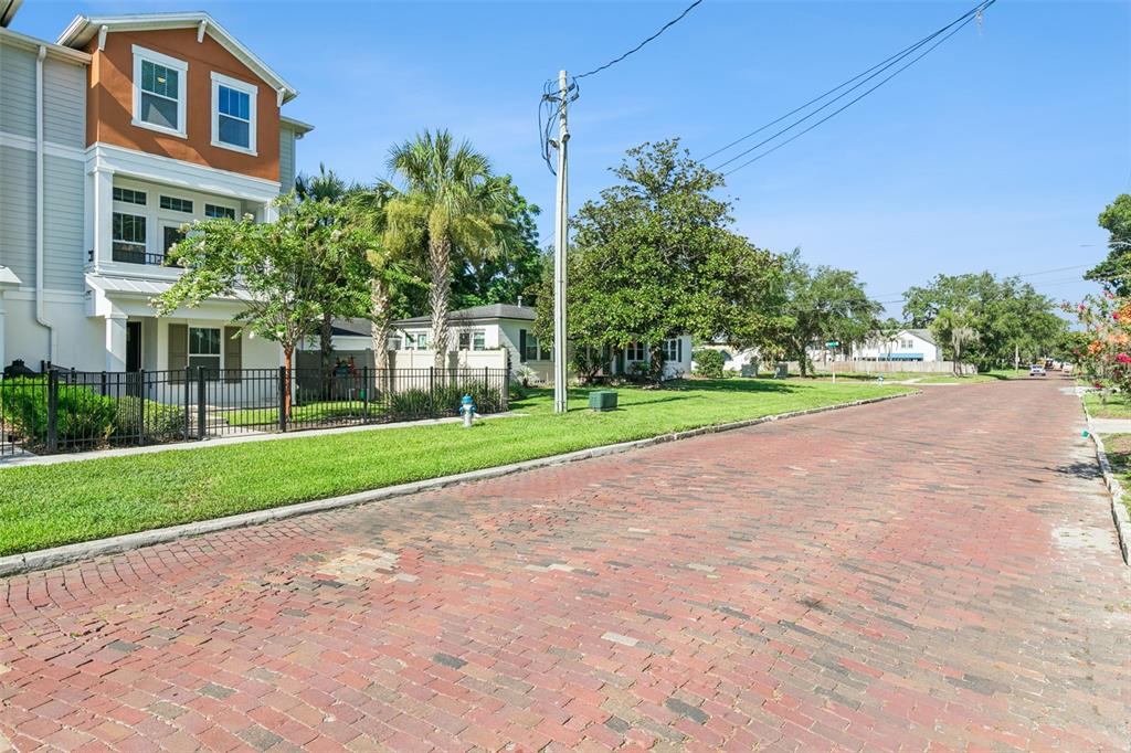 A brick street runs in front of a multi-story house with a fenced lawn — 1012 E MARKS STREET, ORLANDO, FL