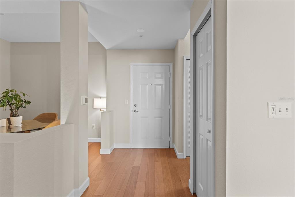 A bright entryway features wood flooring, a white front door, and a nearby dining area — 1064 N TAMIAMI TRAIL UNIT 1525, SARASOTA, FL