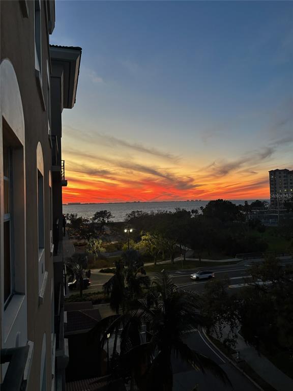 An elevated view of a sunset over the ocean from a building balcony — 1064 N TAMIAMI TRAIL UNIT 1525, SARASOTA, FL