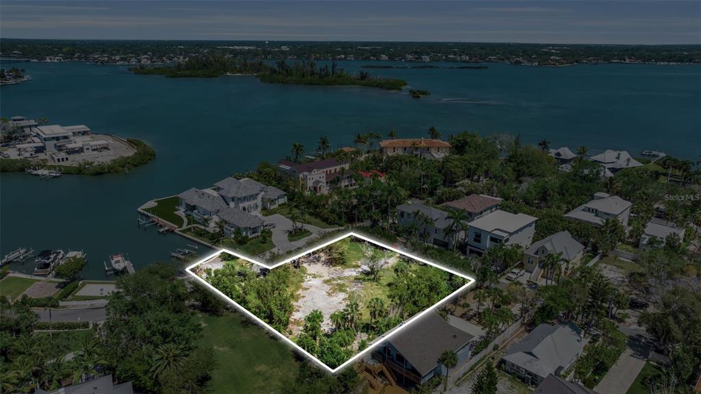 An aerial view shows a vacant, tree-covered residential lot outlined in white near the water — 0 ROBERTS POINT ROAD, SARASOTA, FL