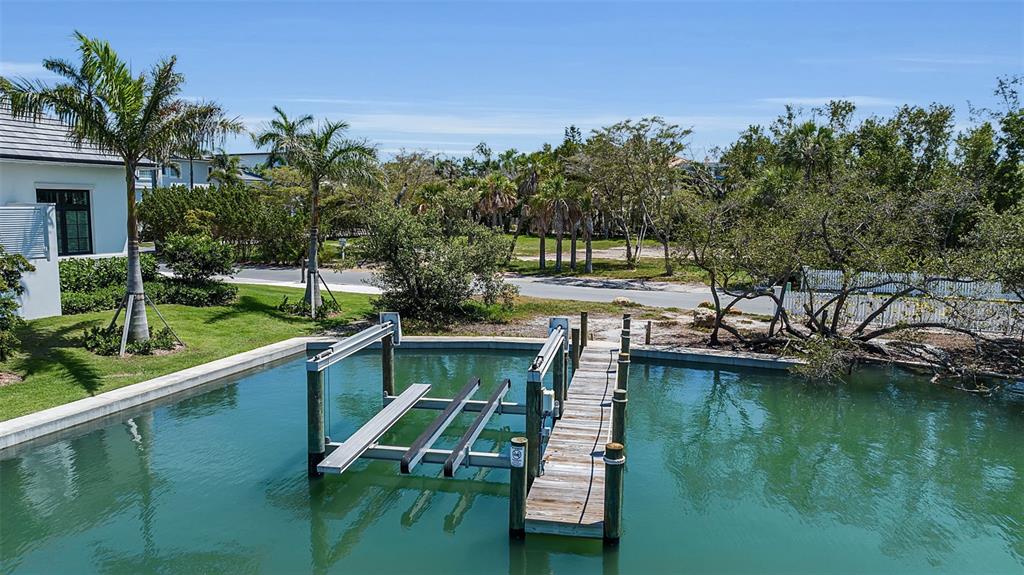 An elevated view of a boat lift and wooden dock extending into a canal — 0 ROBERTS POINT ROAD, SARASOTA, FL