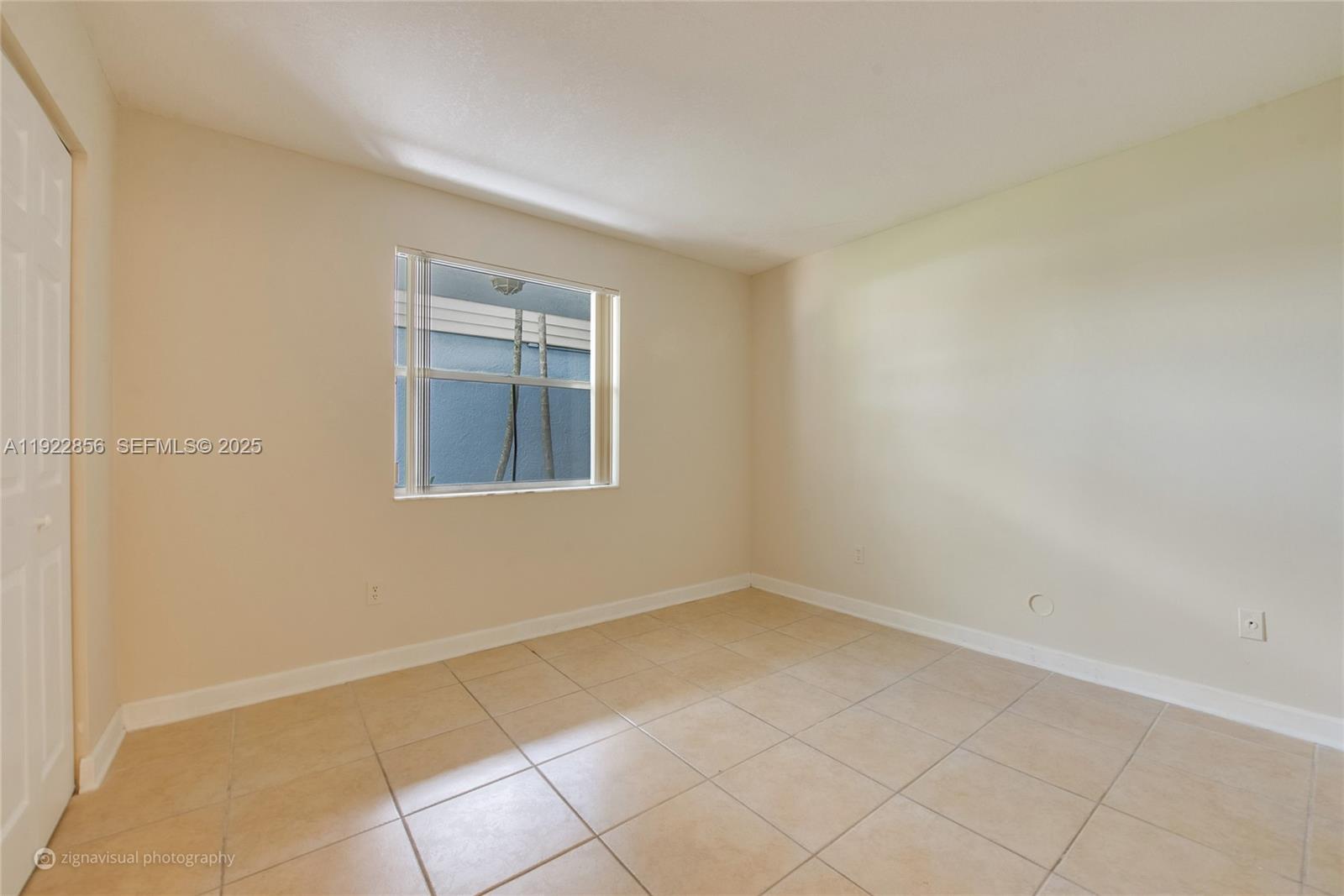 An empty room features beige tile flooring, light-colored walls, and a single window — 4600 SW 67th Ave # 125, Miami FL 33155, MIAMI, FL