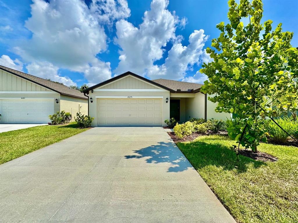 A single-story house with a beige exterior, a two-car garage, and a concrete driveway — 10275 PURPLE LEAF COURT, RIVERVIEW, FL