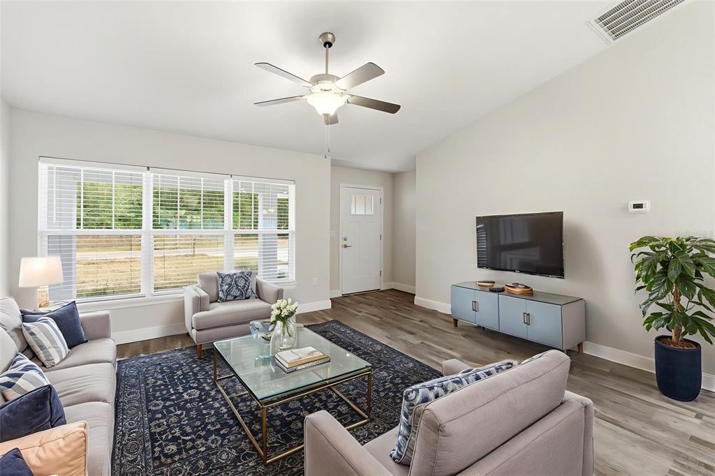 A living room features a ceiling fan, a television, a glass coffee table, and furniture — 9960 N SHERMAN DRIVE, CITRUS SPRINGS, FL
