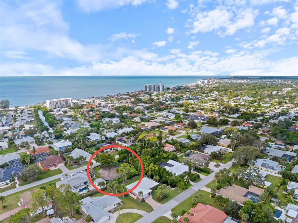 An aerial view shows a residential neighborhood with a red circle highlighting a vacant lot — 621 HIBISCUS DRIVE, VENICE, FL