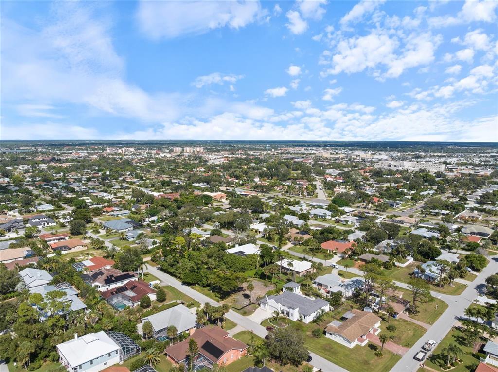 An aerial view shows a suburban neighborhood with houses, swimming pools, and tree-lined streets — 621 HIBISCUS DRIVE, VENICE, FL