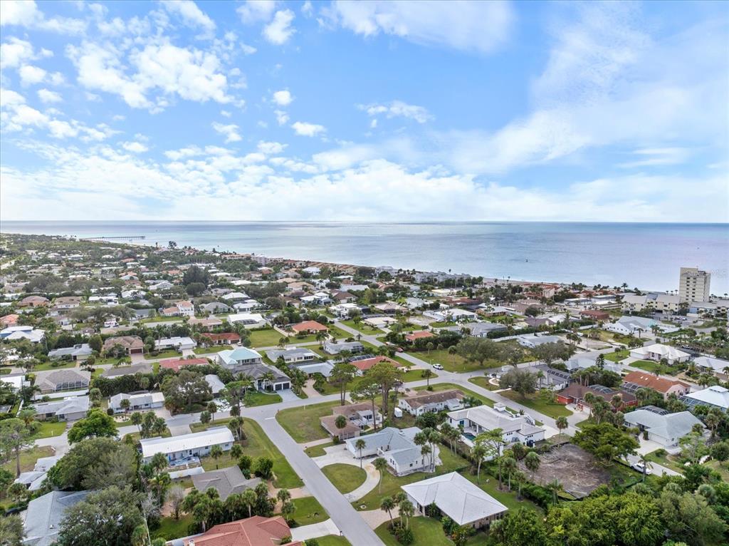 An aerial view of a coastal residential neighborhood with houses, palm trees, and the ocean — 621 HIBISCUS DRIVE, VENICE, FL