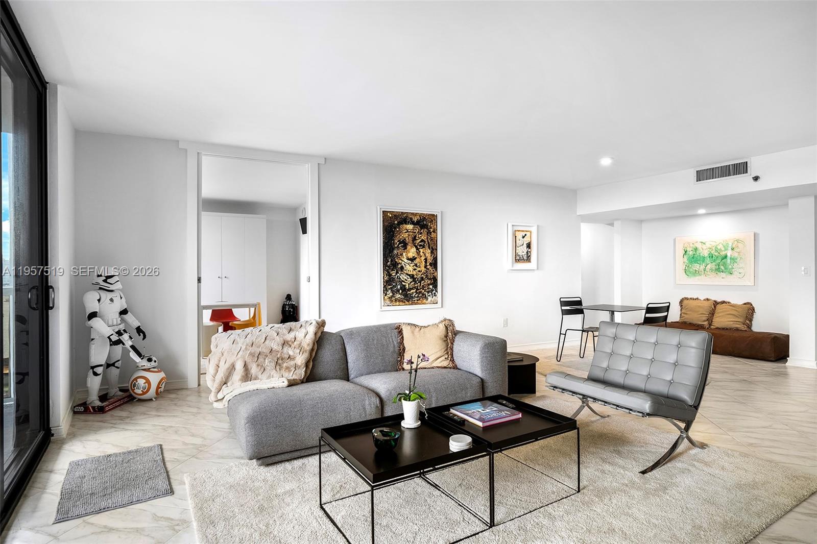 A living room features a grey sofa, a Barcelona chair, and Star Wars decor — 9 Island Ave # 710, Miami Beach FL 33139, MIAMI BEACH, FL