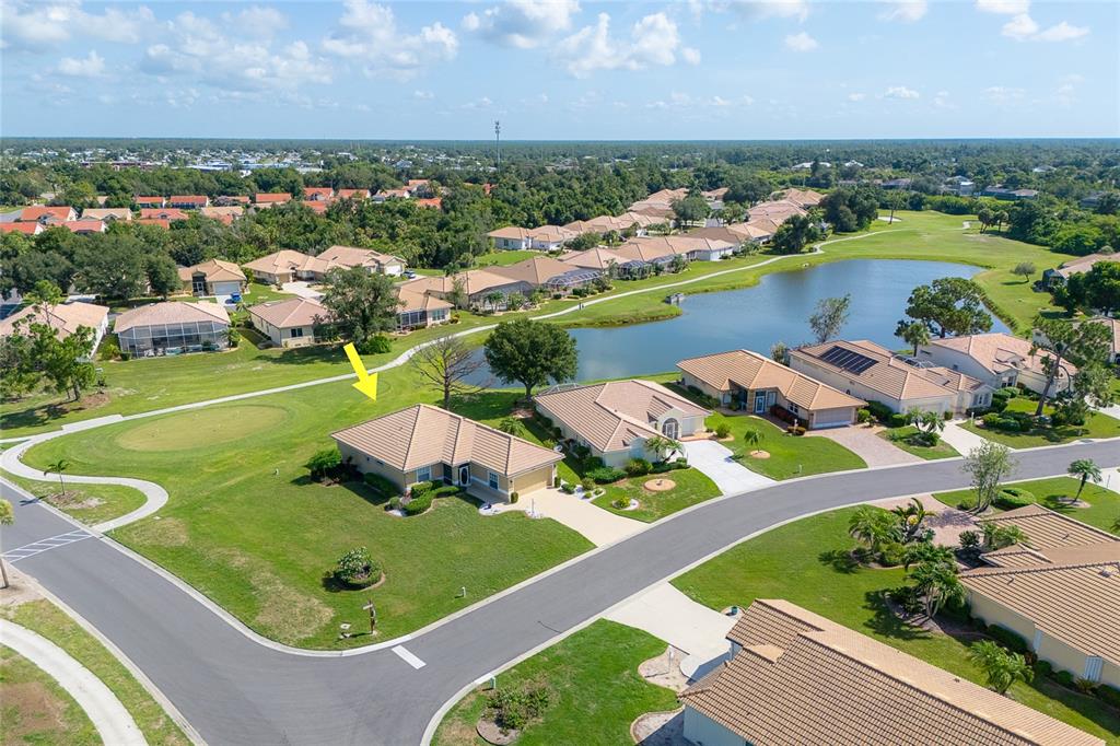 An aerial view shows a suburban house with a tile roof situated near a golf course — 6700 GREENVIEW LANE, ENGLEWOOD, FL