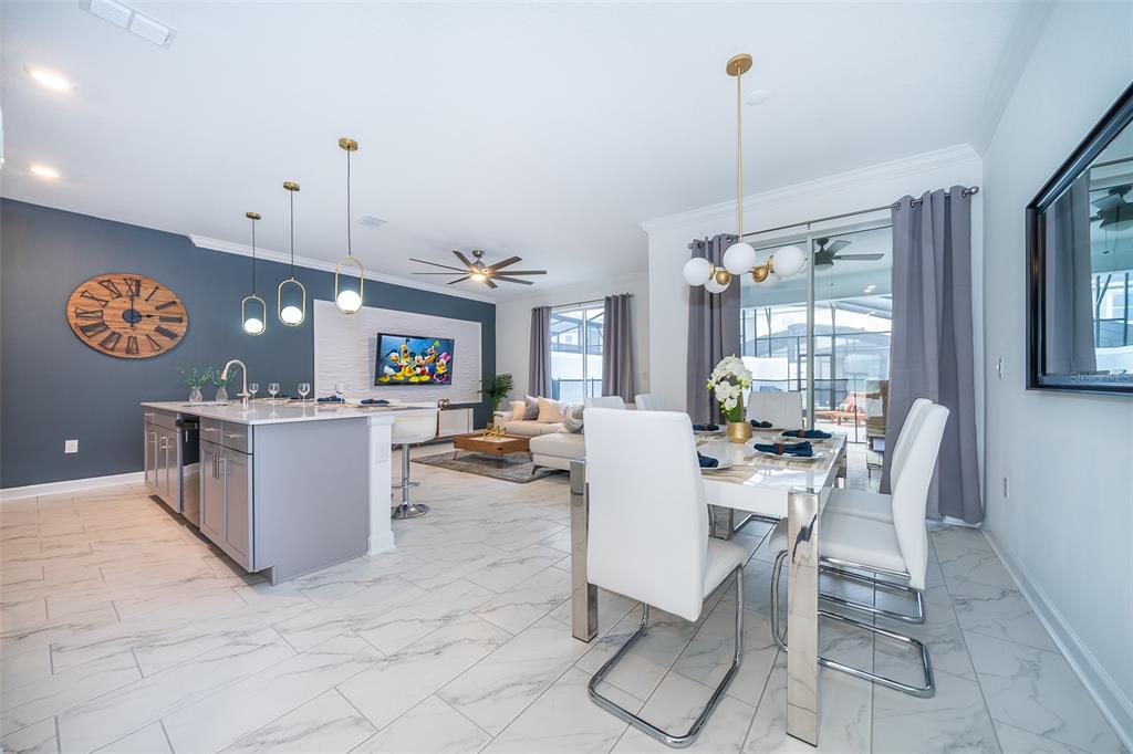 An open-concept kitchen, dining area, and living room featuring white marble-look tile flooring — 2990 PROTAGONIST STREET, KISSIMMEE, FL