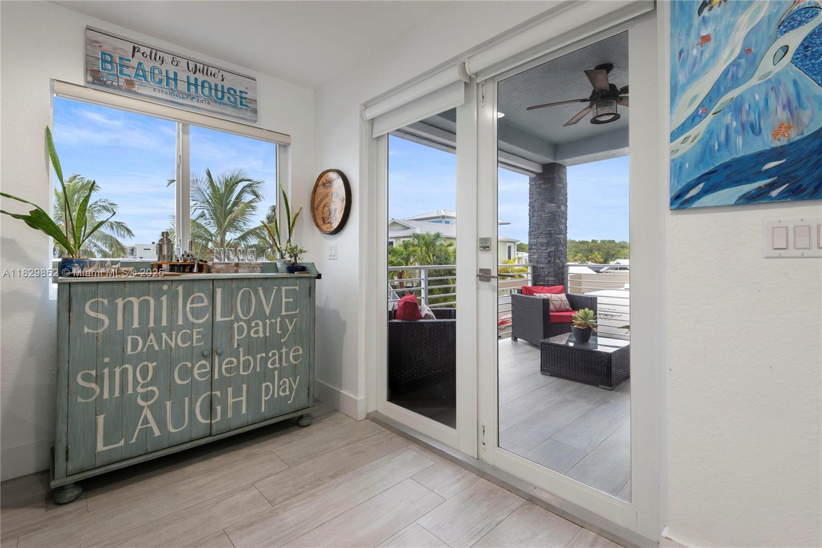A room with a decorative cabinet, a window, and glass doors leading to a balcony — 325 Calusa St 96, Key Largo FL 33037, KEY LARGO, FL