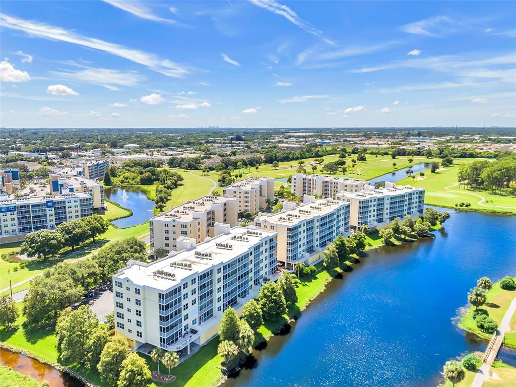 An aerial view of multi-story apartment buildings situated along a lake and golf course — 1200 COUNTRY CLUB DRIVE UNIT 5402, LARGO, FL