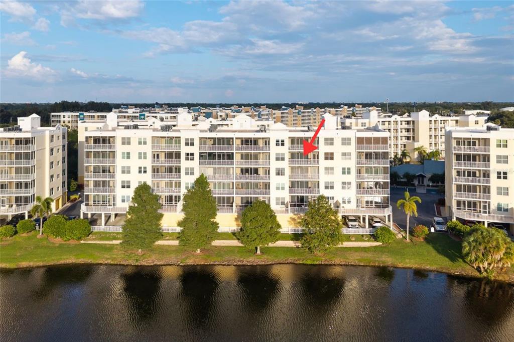An aerial view of a multi-story apartment building situated next to a lake — 1200 COUNTRY CLUB DRIVE UNIT 5402, LARGO, FL
