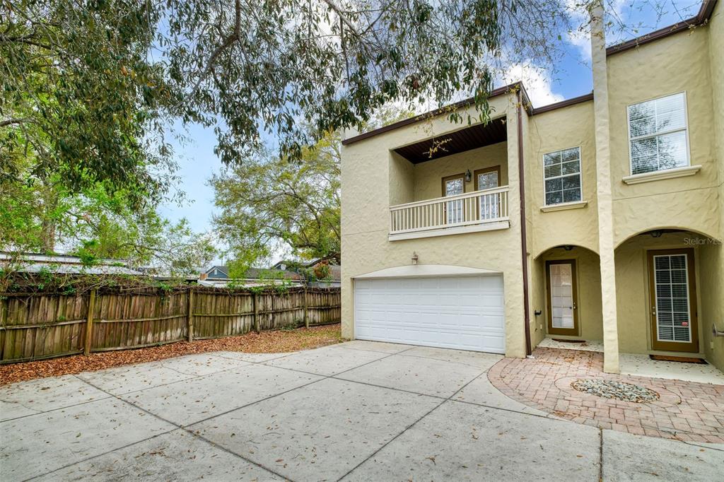 A two-story stucco house features a white garage door, a balcony, and a paved driveway — 1807 HAMMERLIN AVENUE UNIT G, WINTER PARK, FL