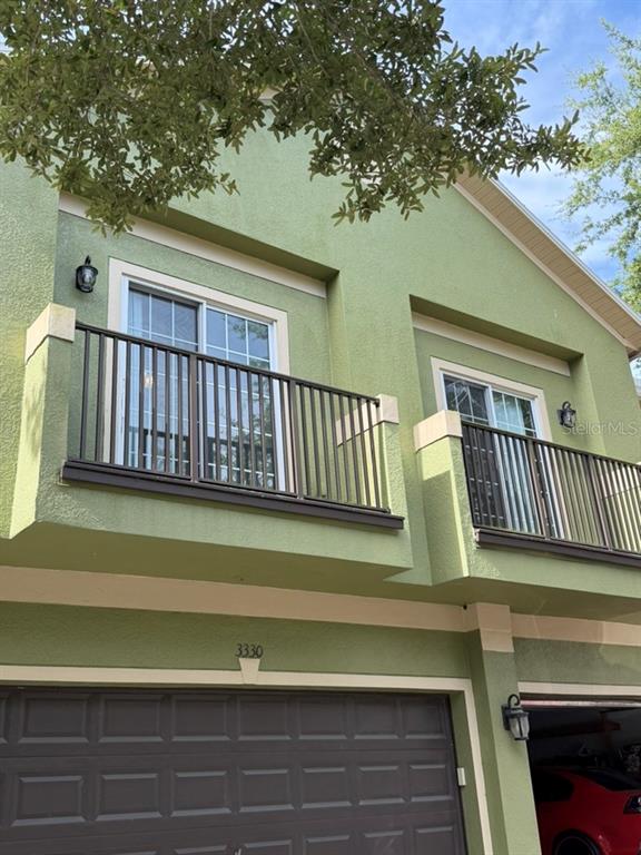 The exterior of a green two-story building features two balconies with dark metal railings — 3310 PINE OAK TRAIL, SANFORD, FL