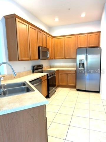 A kitchen features light wood cabinets, stainless steel appliances, and a double-basin sink — 3310 PINE OAK TRAIL, SANFORD, FL