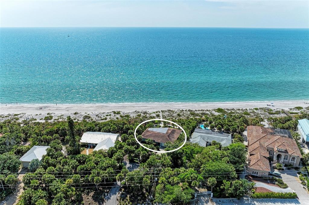 An aerial view shows a house circled in white, nestled among trees near the beach — 8320 MANASOTA KEY ROAD, ENGLEWOOD, FL