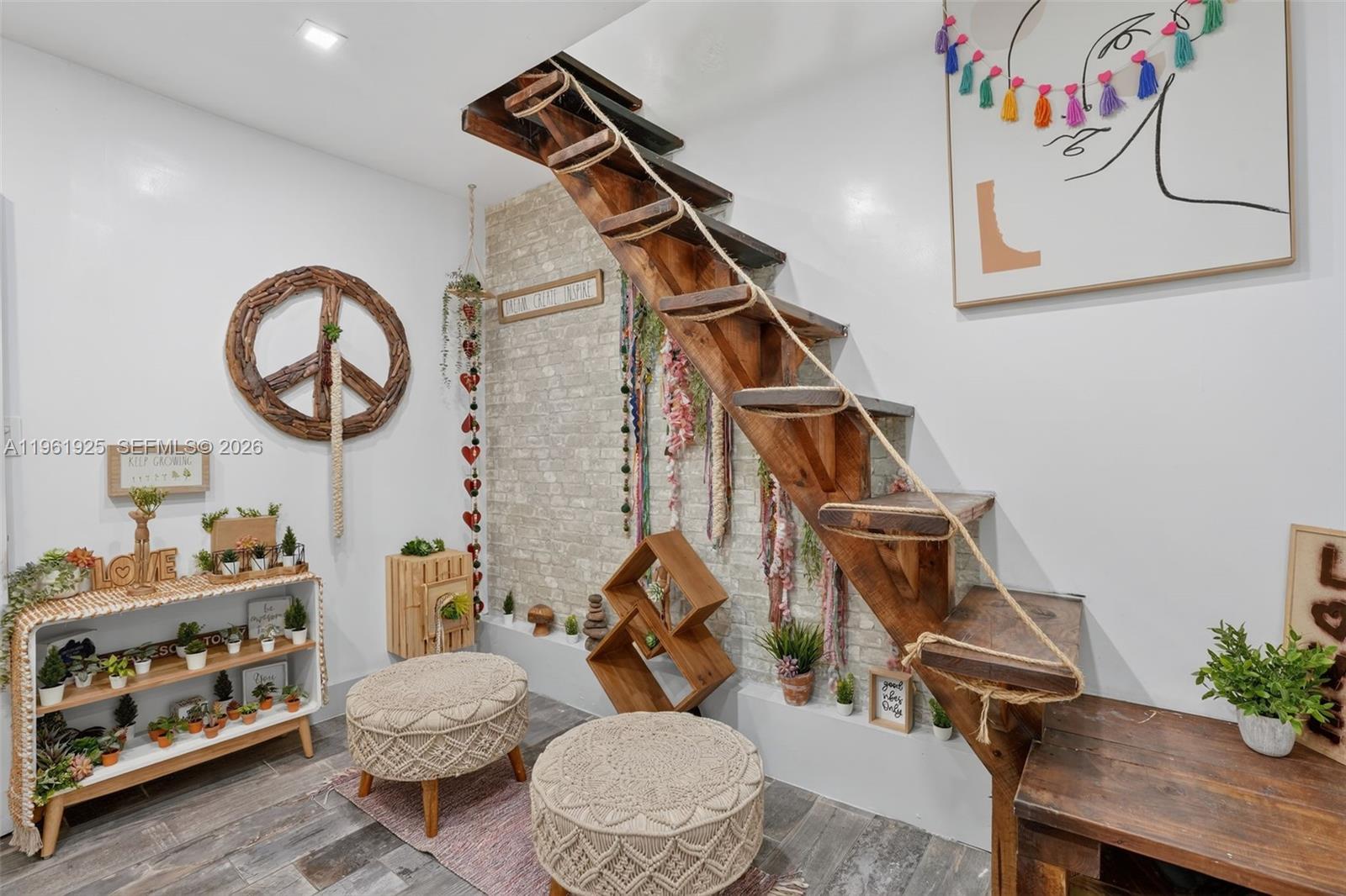 A room features a wooden staircase with rope railings, a brick accent wall, and decor — 8750 W Flagler St # 2, Miami FL 33174, MIAMI, FL