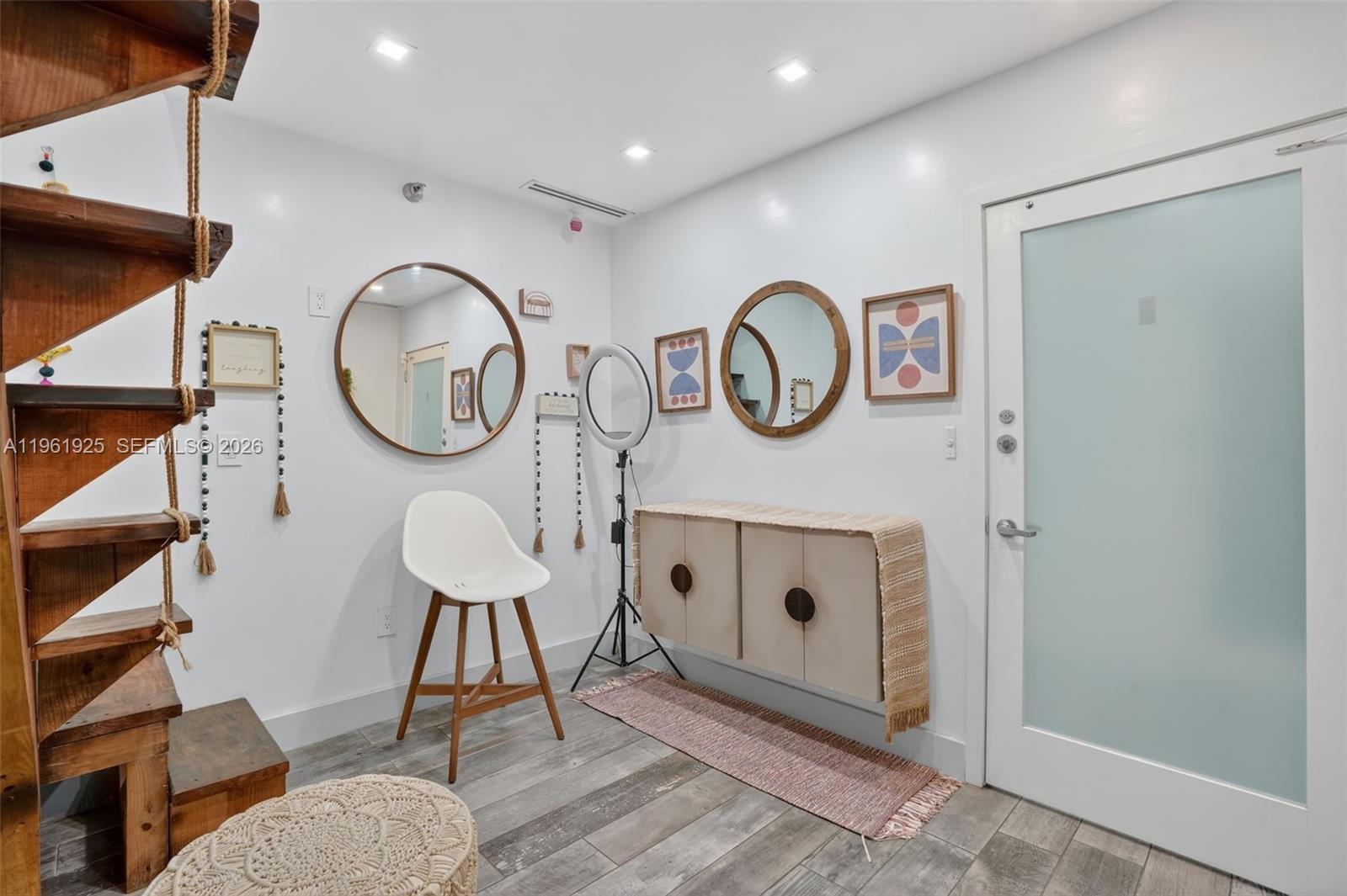 A room features a wooden staircase, a white chair, two round mirrors, and a wall-mounted cabinet — 8750 W Flagler St # 2, Miami FL 33174, MIAMI, FL