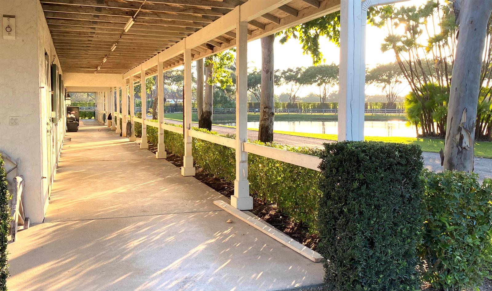 A covered walkway with white pillars overlooks a pond and trees at sunset — 5110 S Shore Boulevard, Wellington FL 33449, WELLINGTON, FL
