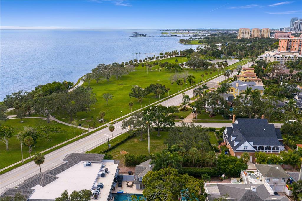 An aerial view shows a coastal park, a road, and residential homes near the water — 1500 N SHORE DRIVE NE, ST PETERSBURG, FL