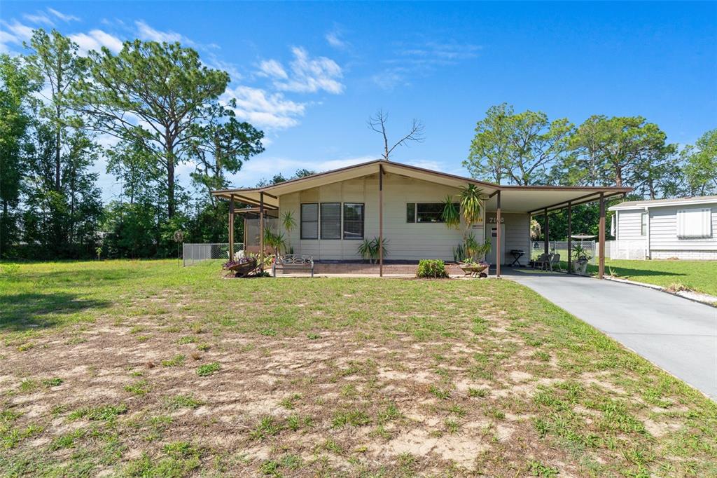 A single-story house with a carport and a large, grassy front yard — 7106 FITZPATRICK AVENUE, BROOKSVILLE, FL