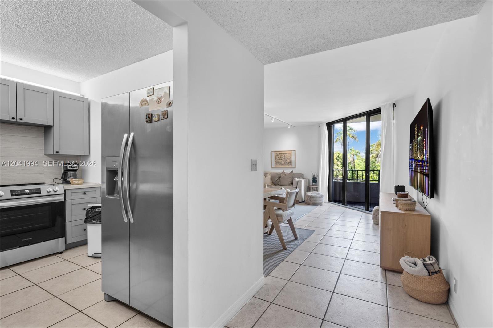 A kitchen with stainless steel appliances opens into a living area with a balcony — 101 Crandon Blvd # 269, Key Biscayne FL 33149, KEY BISCAYNE, FL