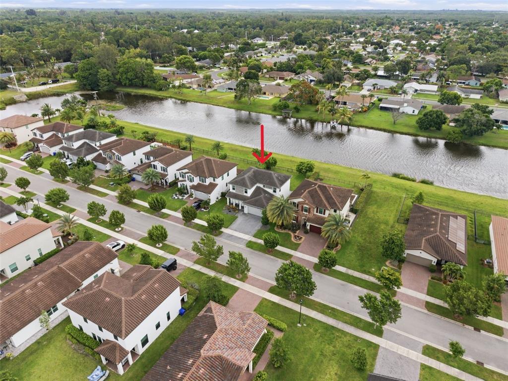 An aerial view shows a two-story house with a red arrow pointing toward its roof — 3266 DUNNING DRIVE, ROYAL PALM BEACH, FL