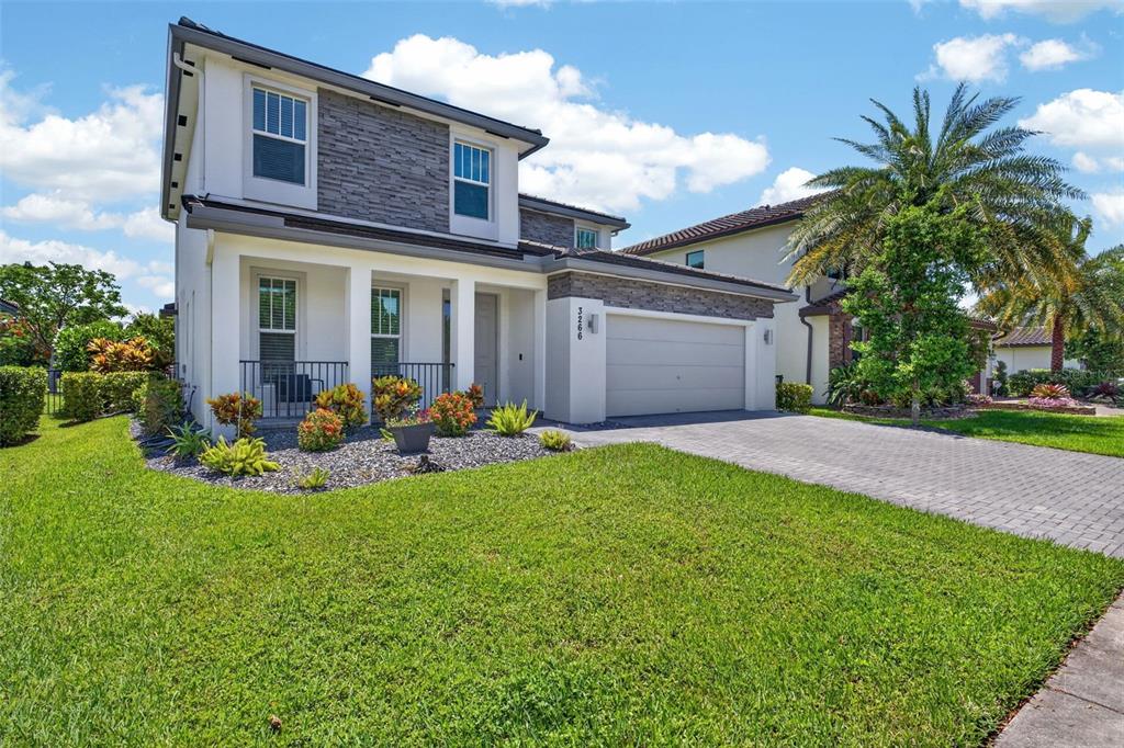A two-story house with a stone facade, a two-car garage, and a landscaped front yard — 3266 DUNNING DRIVE, ROYAL PALM BEACH, FL