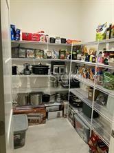 A walk-in pantry with white wire shelving filled with various kitchen appliances and food items — 4258 SW SW 53RD LANE, OCALA, FL