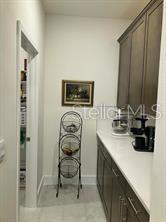 A kitchen butler's pantry features dark wood cabinets, white countertops, and a three-tiered wire basket — 4258 SW SW 53RD LANE, OCALA, FL