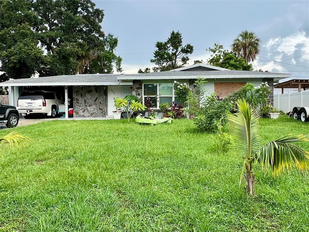 A single-story house with a stone facade, a carport, and a large front lawn — 3246 EAGLE STREET, SARASOTA, FL