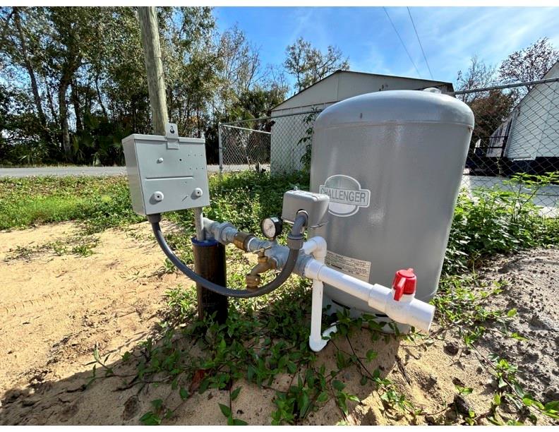 A well pump and pressure tank are installed outdoors on a sandy lot — 0 HOWISON ROAD, KISSIMMEE, FL