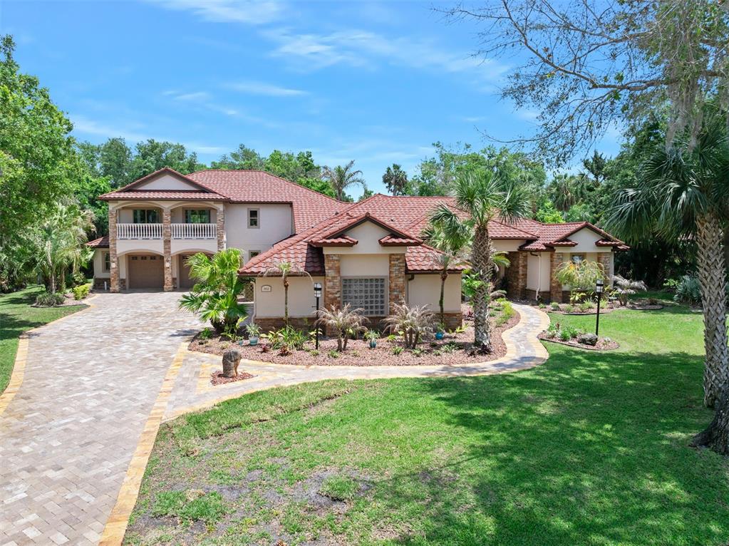 A large house with a paver driveway, four garage doors, and a second-story balcony — 3513 KILGALLEN COURT, ORMOND BEACH, FL
